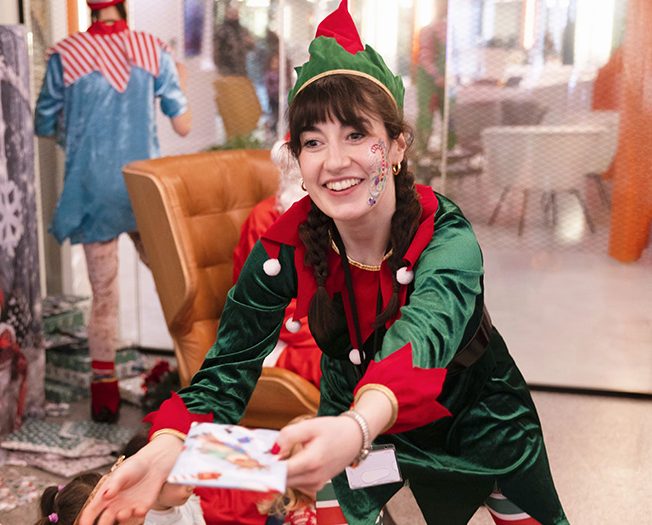 Ermie Elf gives a Christmas gift to the child at this corporate party in Lonon